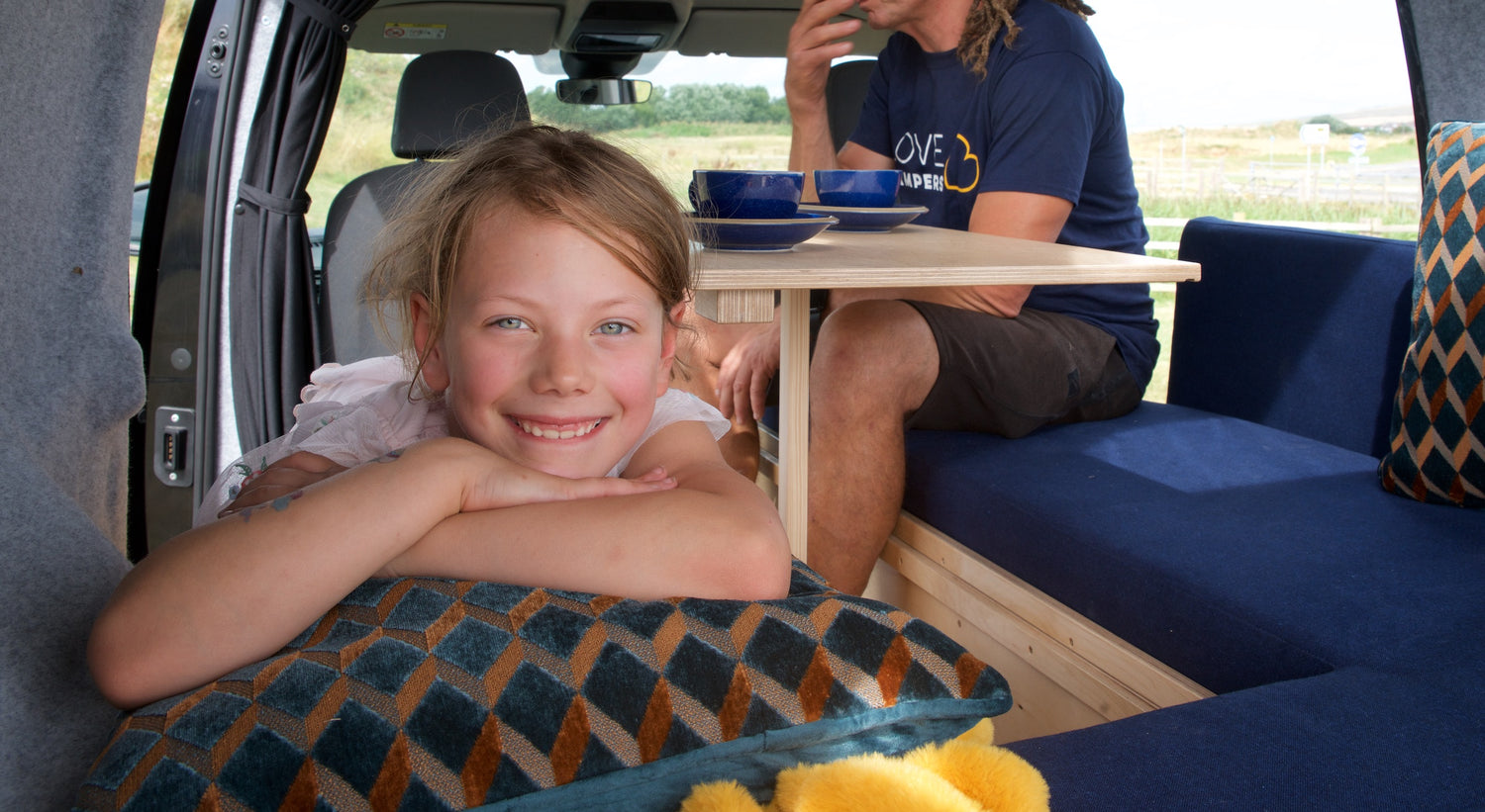 A child smiles while lounging on the Sunbox